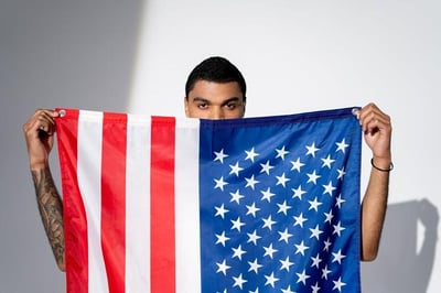 Persona parada detras de una bandera de Estados Unidos